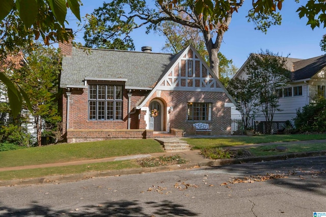 tudor-style house featuring a front lawn