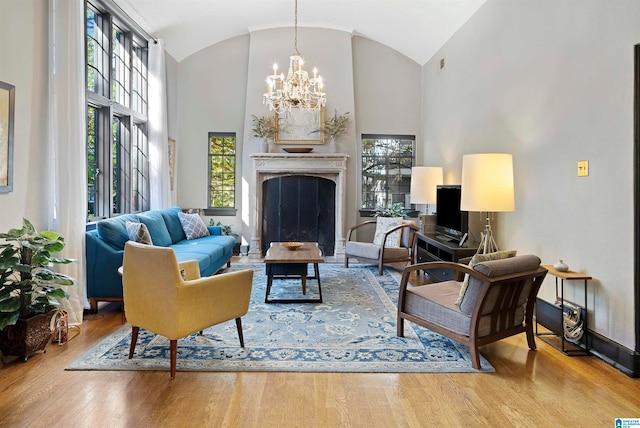 living room with hardwood / wood-style flooring, a chandelier, and high vaulted ceiling