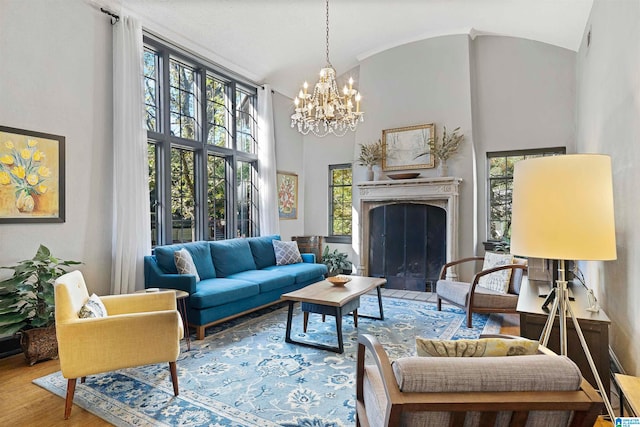 living room featuring high vaulted ceiling, a chandelier, and hardwood / wood-style floors