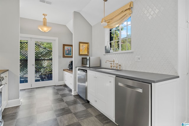 kitchen with stainless steel appliances, hanging light fixtures, a healthy amount of sunlight, and lofted ceiling