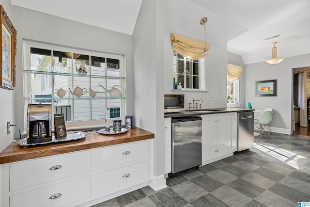 kitchen with hanging light fixtures, lofted ceiling, wood counters, and appliances with stainless steel finishes