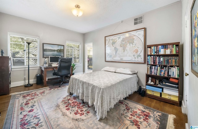 bedroom featuring a textured ceiling, dark wood-type flooring, and multiple windows