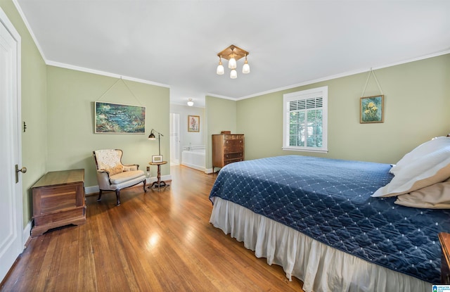 bedroom featuring hardwood / wood-style floors, connected bathroom, and crown molding