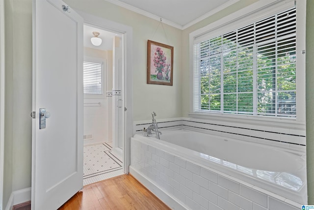 bathroom featuring hardwood / wood-style floors, tiled bath, and a healthy amount of sunlight