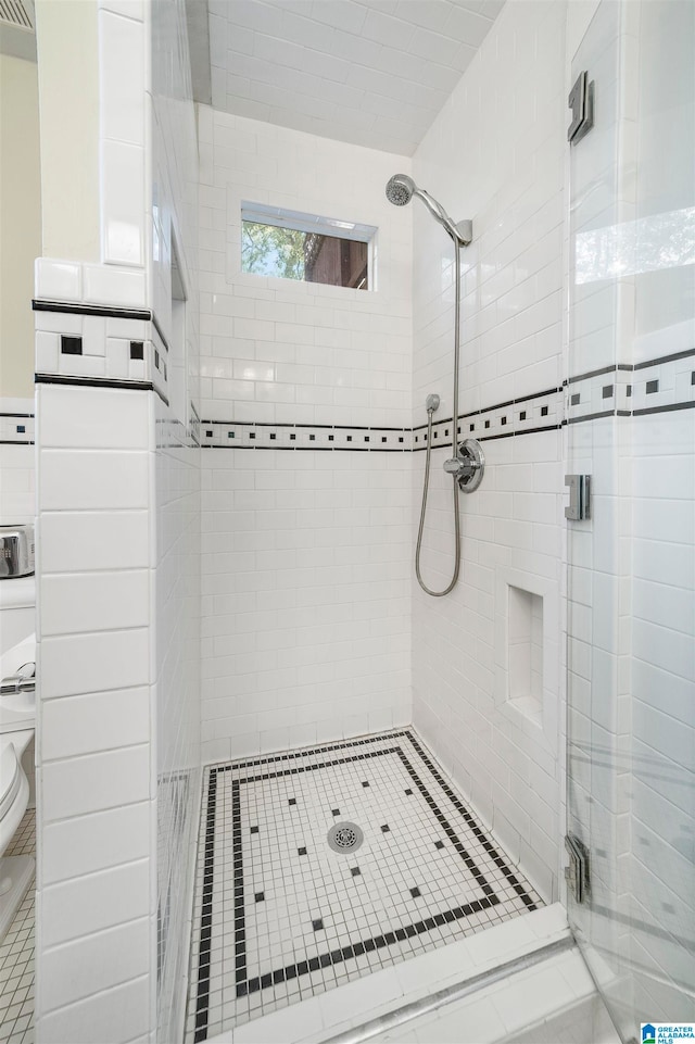 bathroom with tile patterned floors, toilet, and an enclosed shower