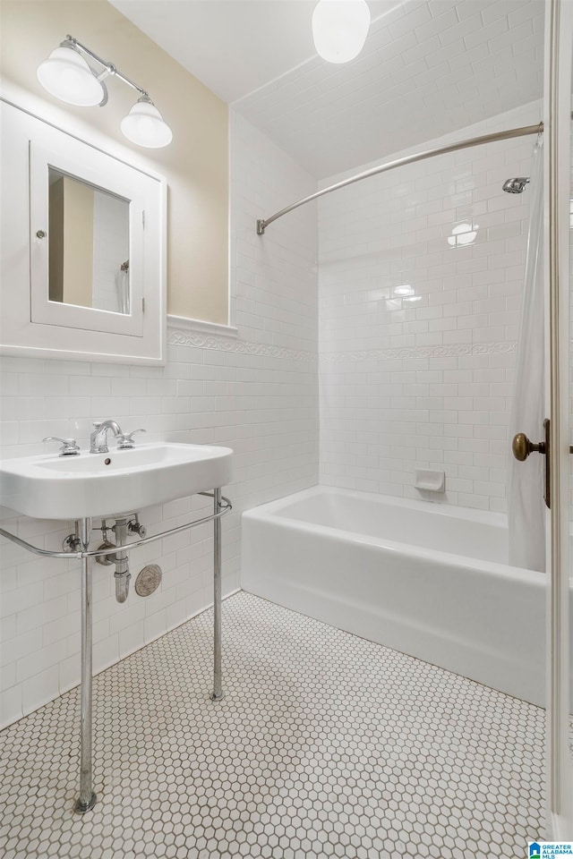 bathroom with tile patterned flooring, tile walls, and tiled shower / bath combo