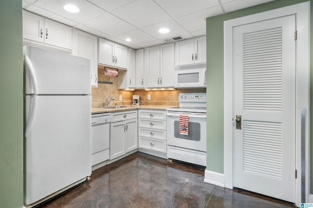 kitchen with white cabinetry, backsplash, a paneled ceiling, sink, and white appliances