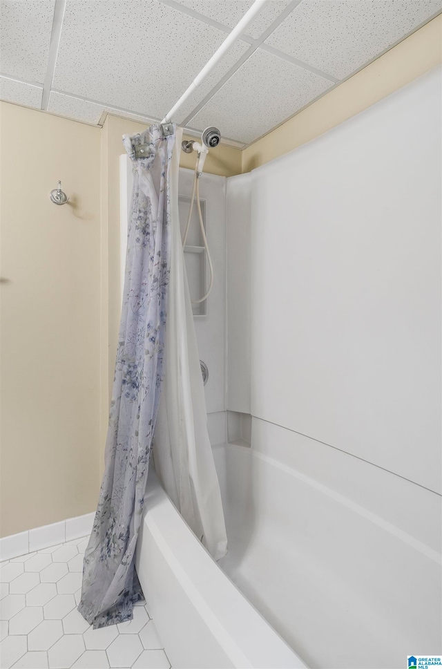 bathroom featuring shower / bath combo, a drop ceiling, and tile patterned floors