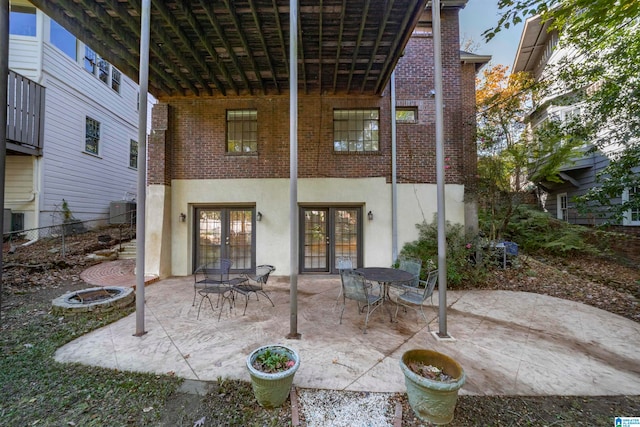 rear view of house featuring a patio area, french doors, and a fire pit