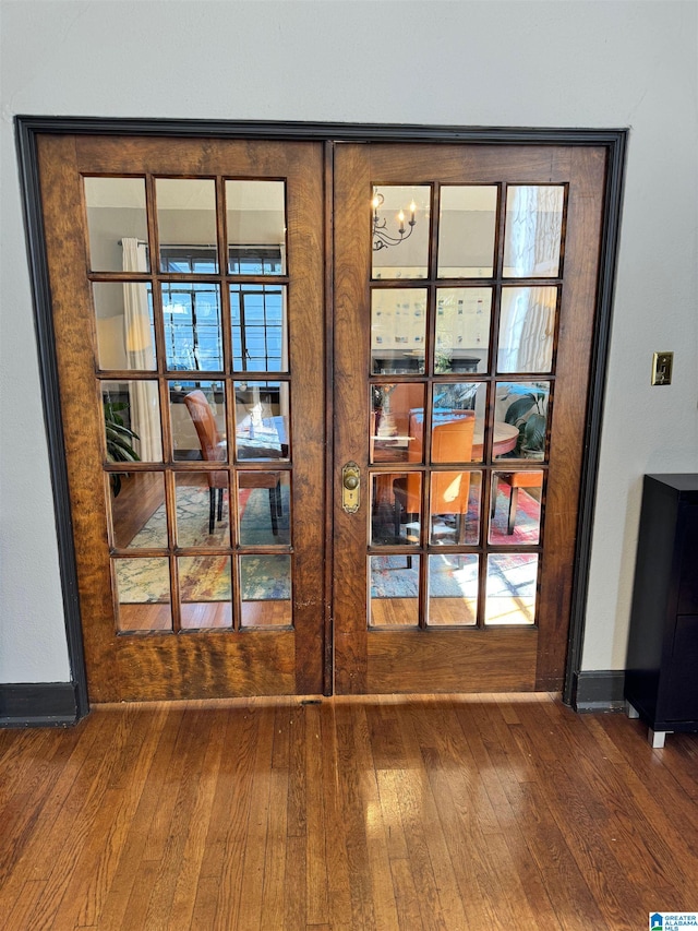 entryway with wood-type flooring and a chandelier