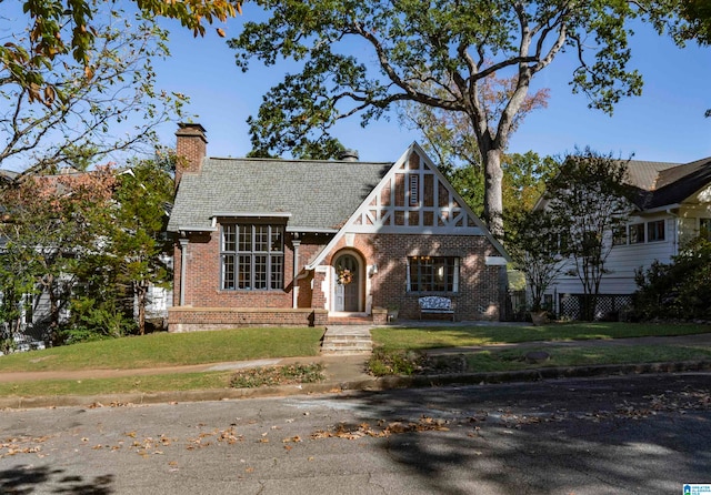 tudor-style house with a front lawn