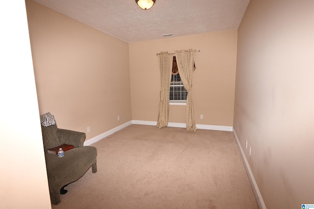 unfurnished room featuring light colored carpet and a textured ceiling