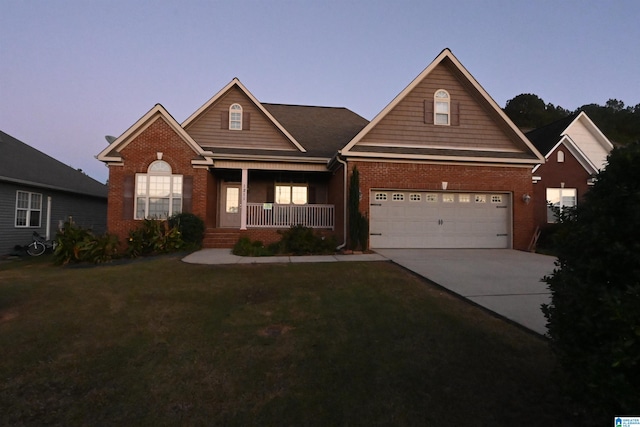 view of front of home with a porch, a lawn, and a garage