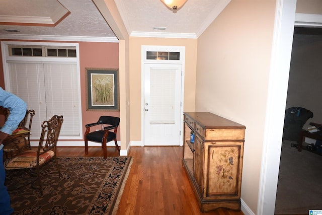 foyer entrance featuring dark hardwood / wood-style flooring, a textured ceiling, and ornamental molding