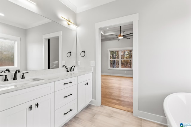 bathroom featuring a washtub, vanity, ceiling fan, and a healthy amount of sunlight