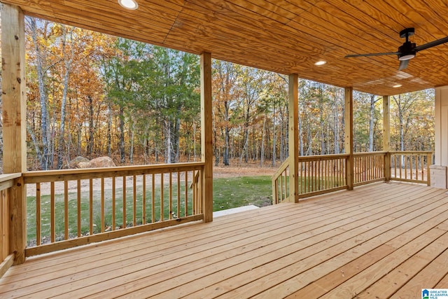 wooden terrace with ceiling fan and a yard