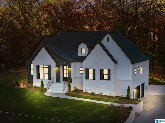 modern inspired farmhouse featuring a garage and a front lawn