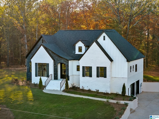 modern inspired farmhouse featuring a garage and a front lawn