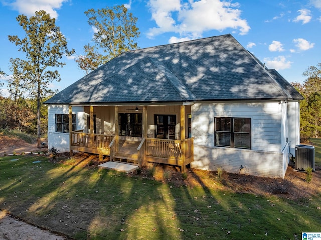 rear view of house featuring central AC, a yard, and a porch