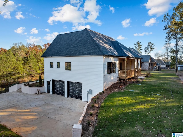 view of side of property featuring a garage and a lawn