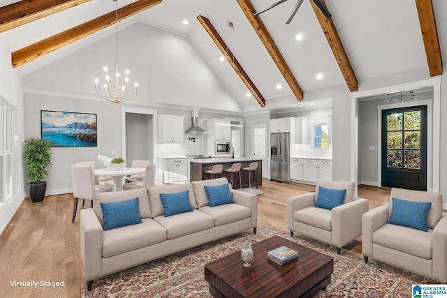 living room featuring sink, high vaulted ceiling, a chandelier, and light wood-type flooring