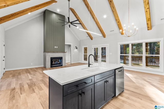 kitchen featuring a large fireplace, dishwasher, high vaulted ceiling, pendant lighting, and a kitchen island with sink