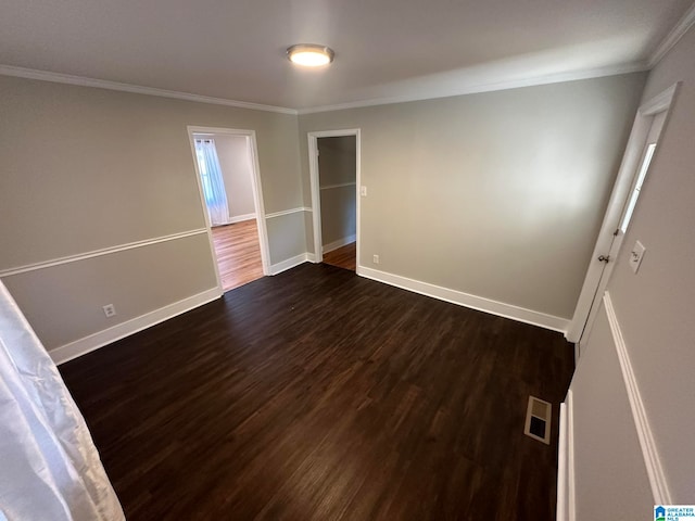 empty room featuring dark hardwood / wood-style floors and ornamental molding