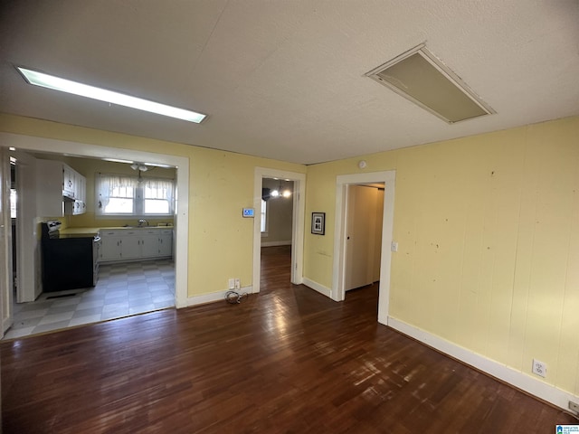 spare room with a textured ceiling, dark hardwood / wood-style flooring, and sink