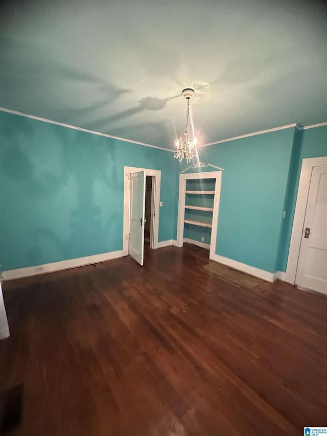 unfurnished dining area with ornamental molding, dark hardwood / wood-style flooring, and a notable chandelier