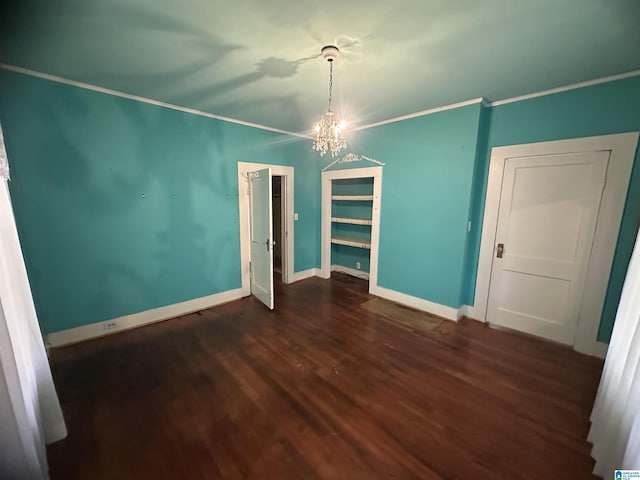 unfurnished dining area featuring dark hardwood / wood-style flooring, an inviting chandelier, and ornamental molding