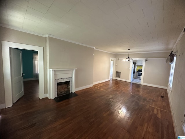 unfurnished living room with an inviting chandelier, dark hardwood / wood-style floors, a stone fireplace, and ornamental molding