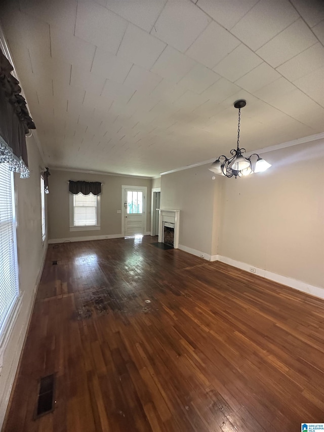 unfurnished living room featuring dark wood-type flooring and a chandelier