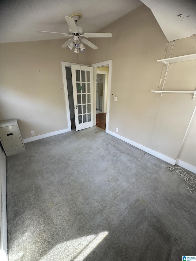 carpeted spare room featuring ceiling fan and vaulted ceiling