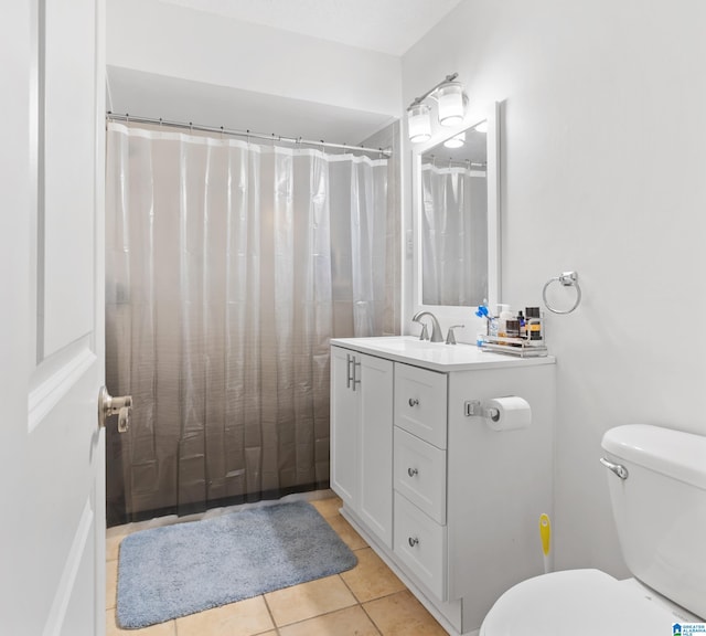 bathroom with toilet, vanity, and tile patterned floors