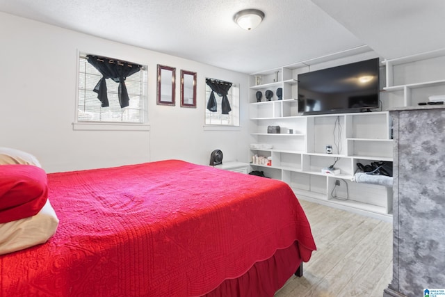 bedroom featuring a textured ceiling and light hardwood / wood-style floors