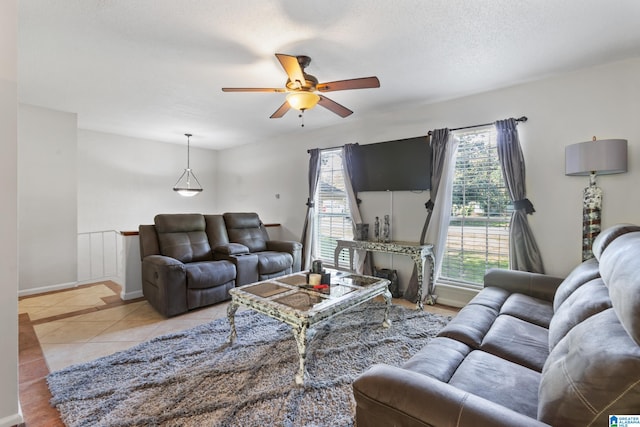 tiled living room with a wealth of natural light, a textured ceiling, and ceiling fan