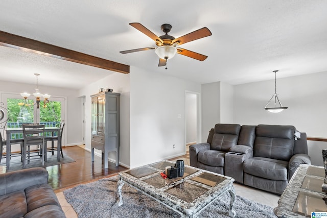 living room with a textured ceiling, beamed ceiling, ceiling fan with notable chandelier, and light wood-type flooring