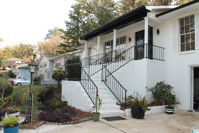 view of side of property with stairway and a porch