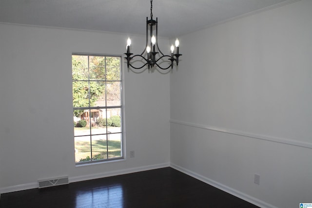 empty room with healthy amount of natural light, a chandelier, crown molding, and baseboards