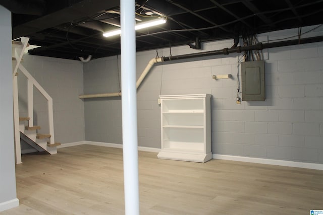 basement featuring hardwood / wood-style floors and electric panel