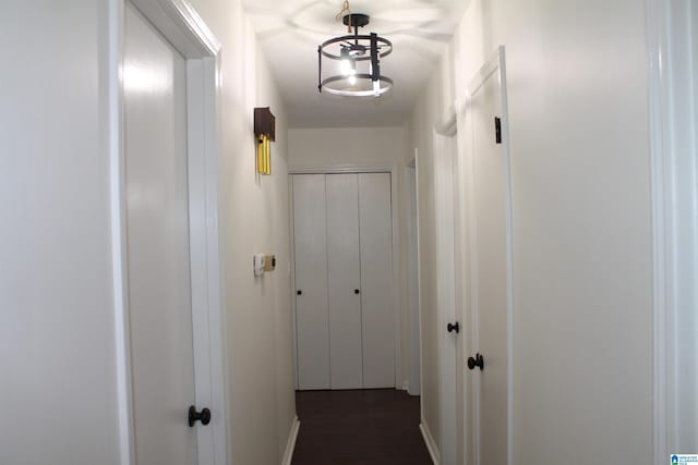 hall featuring baseboards and dark wood-type flooring
