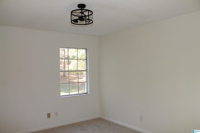 empty room with light colored carpet and baseboards