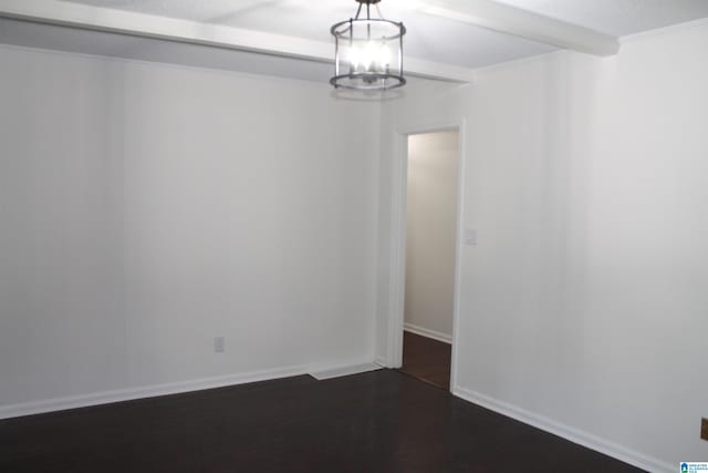 spare room featuring beamed ceiling, dark wood finished floors, a chandelier, and baseboards