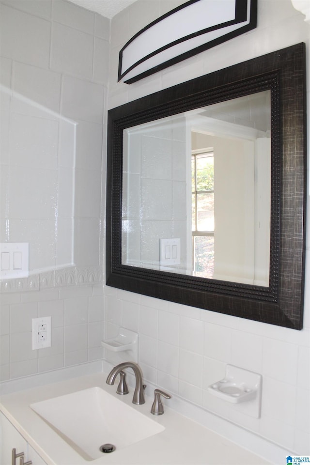 bathroom with a sink and tasteful backsplash