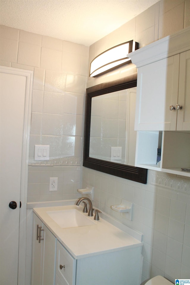 half bath with tile walls, tasteful backsplash, and vanity