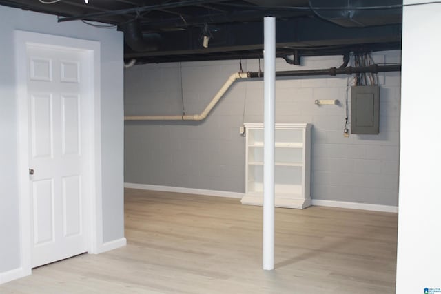 basement with wood-type flooring and electric panel