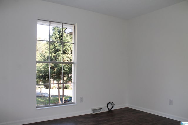 empty room with dark wood-style floors and baseboards