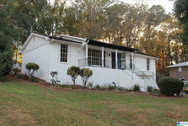 single story home featuring a front yard, a porch, stairway, and stucco siding