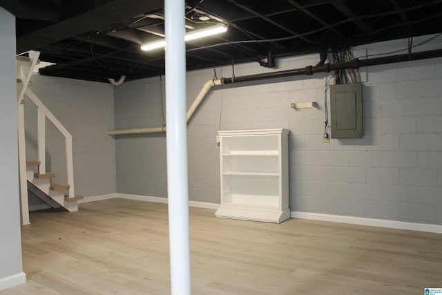 unfinished basement with electric panel, stairway, and wood finished floors