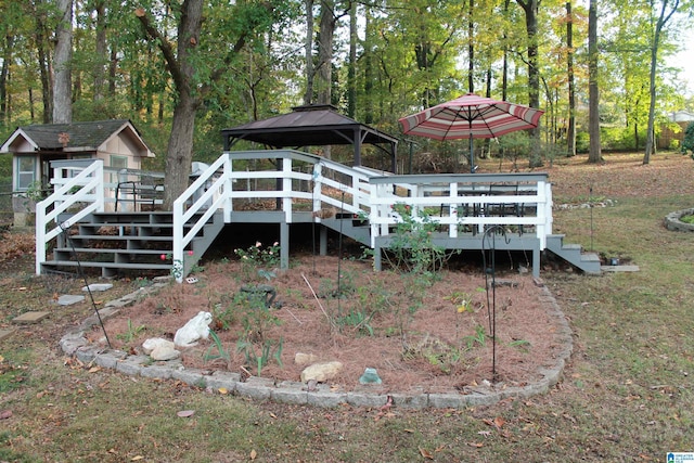 back of property featuring a wooden deck, a gazebo, stairs, and view of wooded area